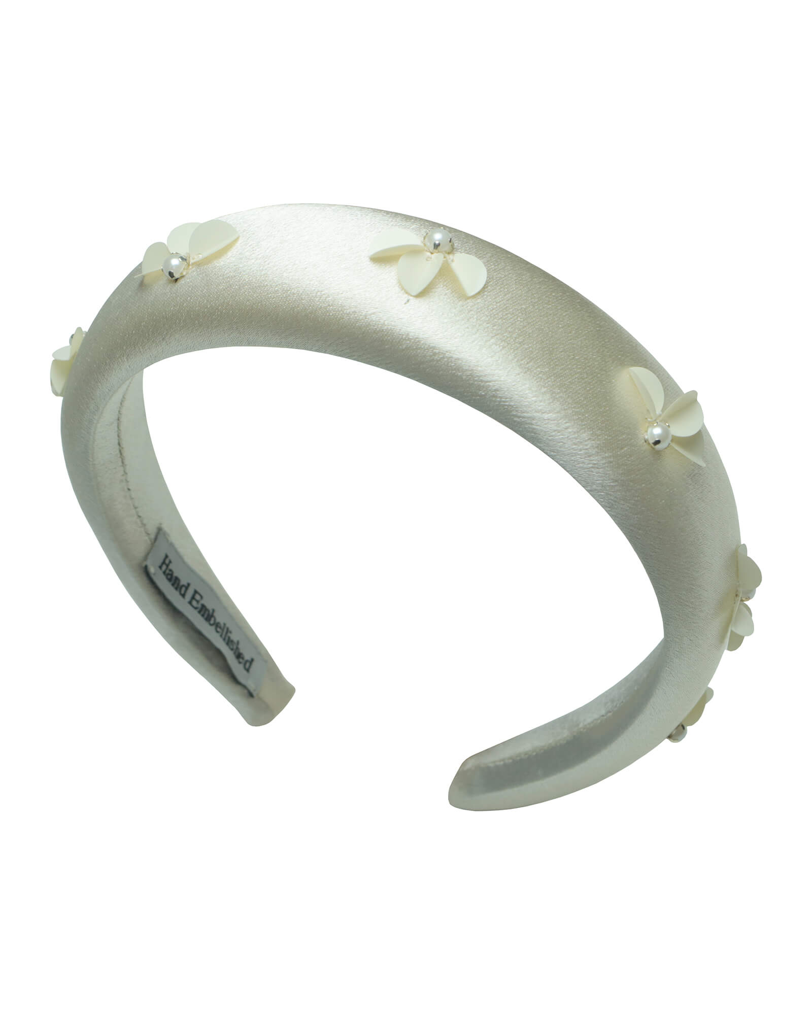 Luxurious ivory satin padded headband, hand-embellished with dimensional sequin flowers and silver-capped pearls. Front three-quarter view showing the intricate craftsmanship and comfort padding.